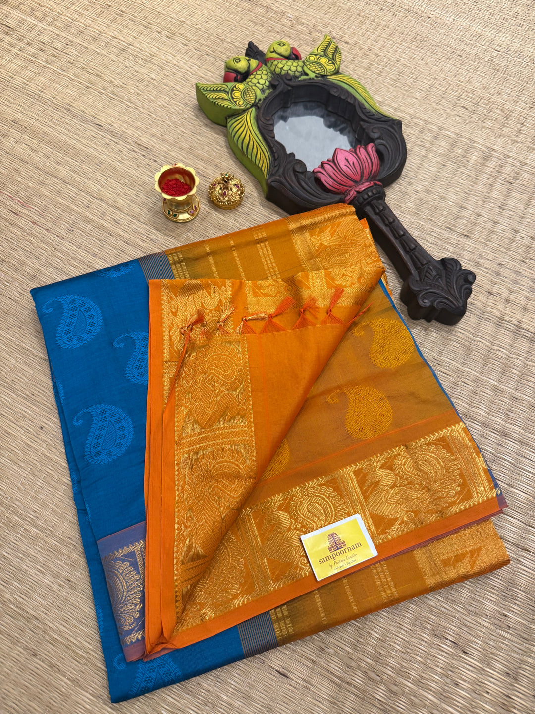 Blue with orange mango embossed prints in the body,traditional borders and rich Pallu Semi Silk Cotton Saree