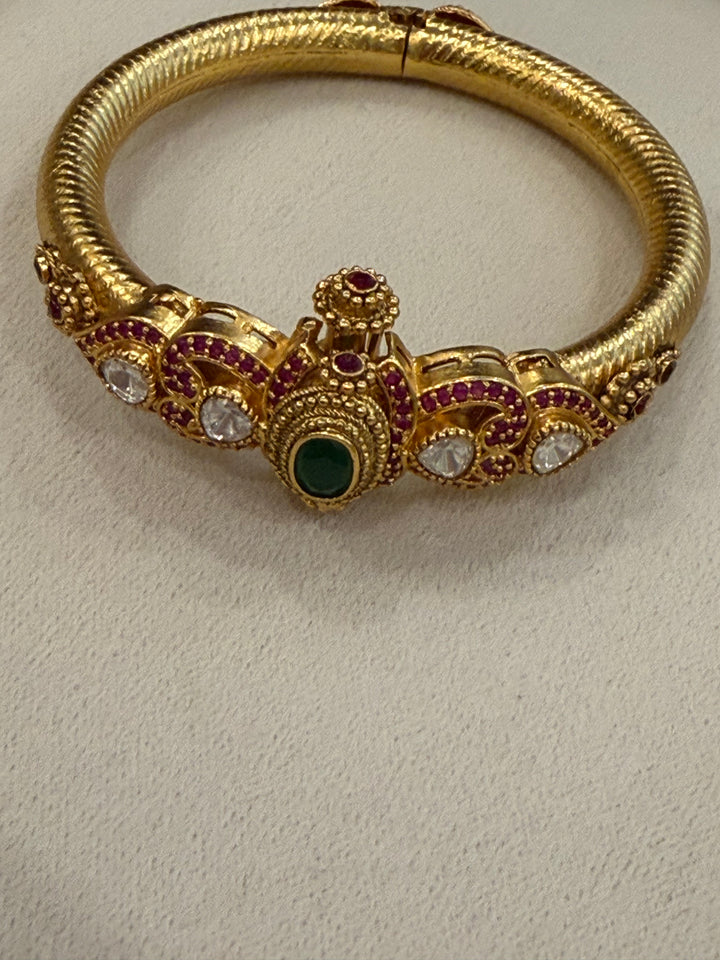 Traditional Kangan Kada with a screw-type closure, beautifully studded with red, green & white stones. One standard size that fits 2/4, 2/6 & 2/8