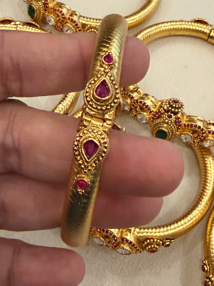 Traditional Kangan Kada with a screw-type closure, beautifully studded with red, green & white stones. One standard size that fits 2/4, 2/6 & 2/8