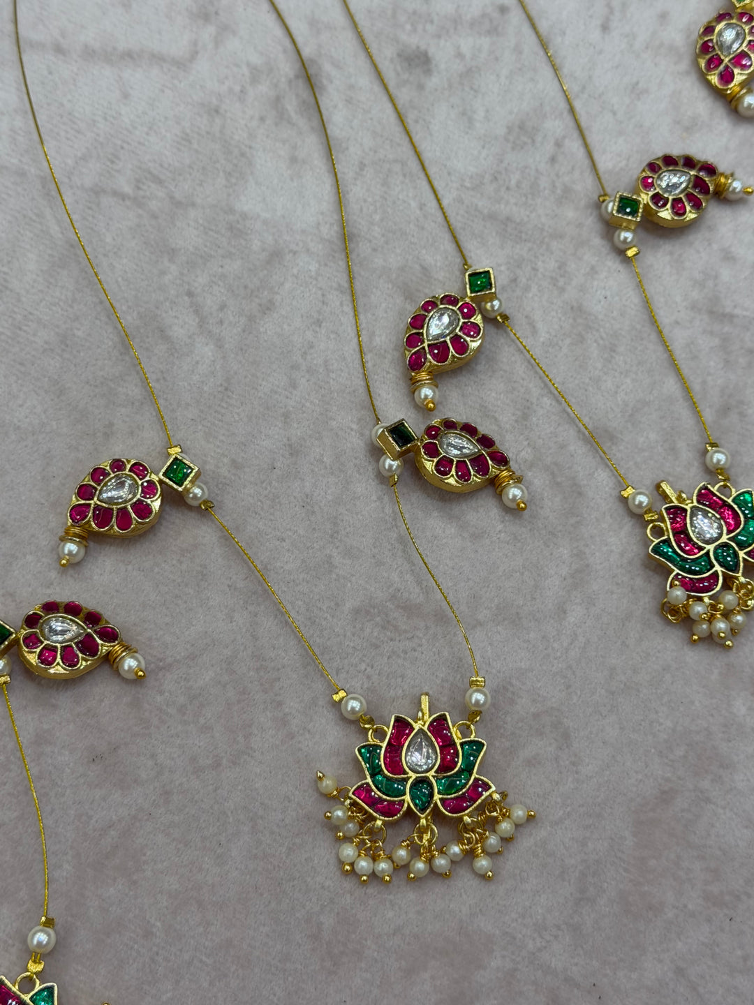 Grace meets tradition in this stunning invisible neckpiece, adorned with Jadau side pendants, a timeless mango motif, and an exquisite Lotus centerpiece.