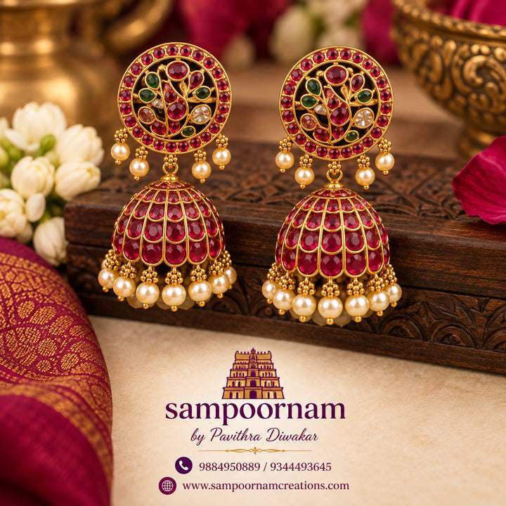 A Gorgeous Peacock - inspired Jhumka Featuring intricate Floral detailing , rich Ruby toned stones and Subtle Green accents. Finished with delicate Pearl drops for an Elegant , Traditional touch