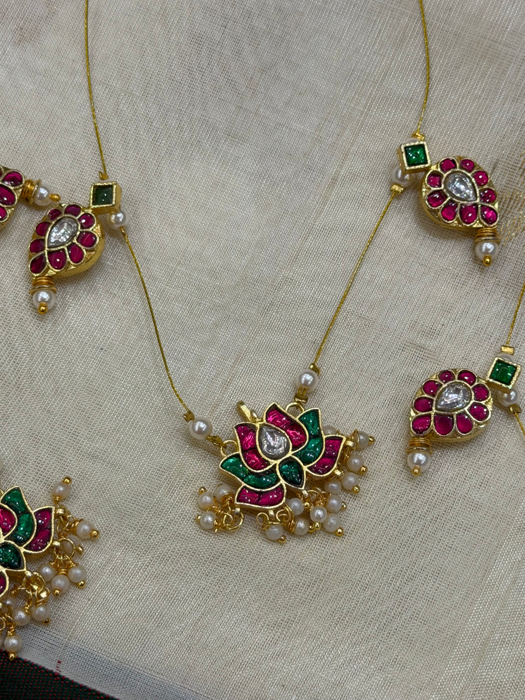 Grace meets tradition in this stunning invisible neckpiece, adorned with Jadau side pendants, a timeless mango motif, and an exquisite Lotus centerpiece.