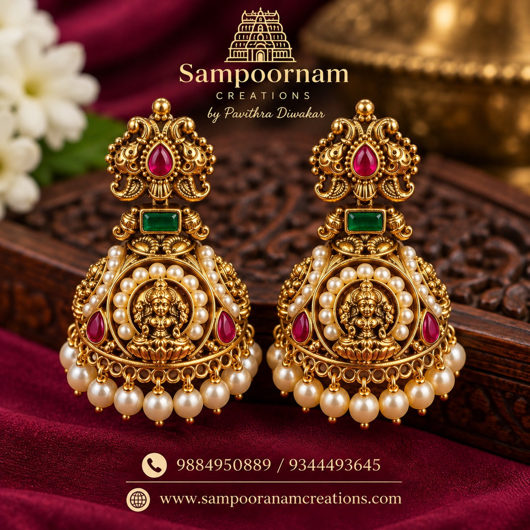 A Magnificent Lakshmi temple - Jewellery - inspired Jhumka featuring an intricate Goddess Lakshmi motif , Rich Ruby -Red and Emerald - Green stones and delicate Pearl detailing , Finished with Cascading Pearl hangings