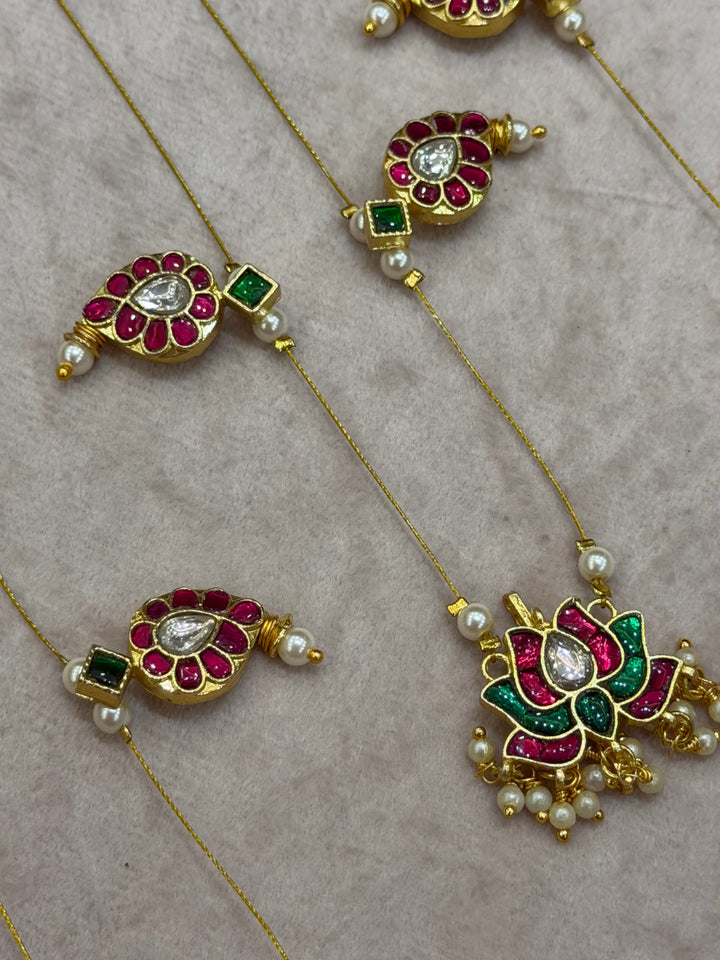 Grace meets tradition in this stunning invisible neckpiece, adorned with Jadau side pendants, a timeless mango motif, and an exquisite Lotus centerpiece.