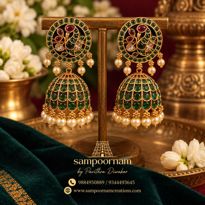A  Gorgeous Peacock - inspired Jhumka Featuring intricate Floral detailing , rich Ruby toned stones and Subtle Green accents. Finished with delicate Pearl drops for an Elegant , Traditional touch