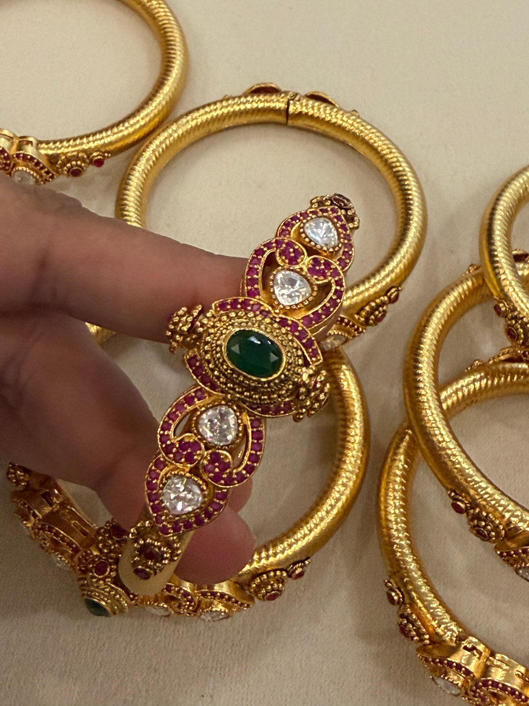 Traditional Kangan Kada with a screw-type closure, beautifully studded with red, green & white stones. One standard size that fits 2/4, 2/6 & 2/8