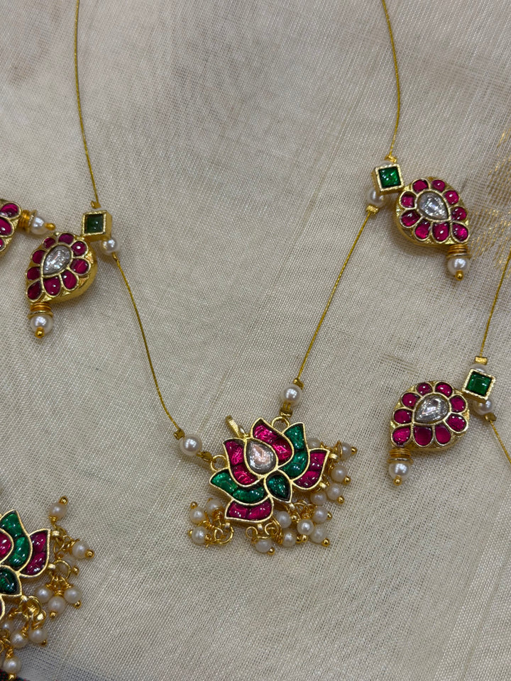 Grace meets tradition in this stunning invisible neckpiece, adorned with Jadau side pendants, a timeless mango motif, and an exquisite Lotus centerpiece.