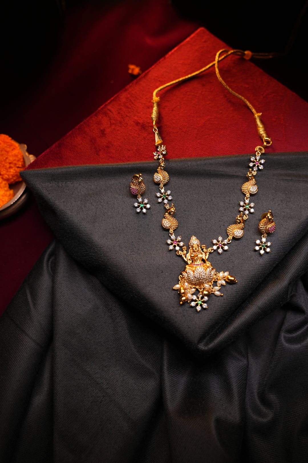 Divine Elegance , A traditional Necklace with a Mahalakshmi Pendant in red green and white stones with peacock detailing