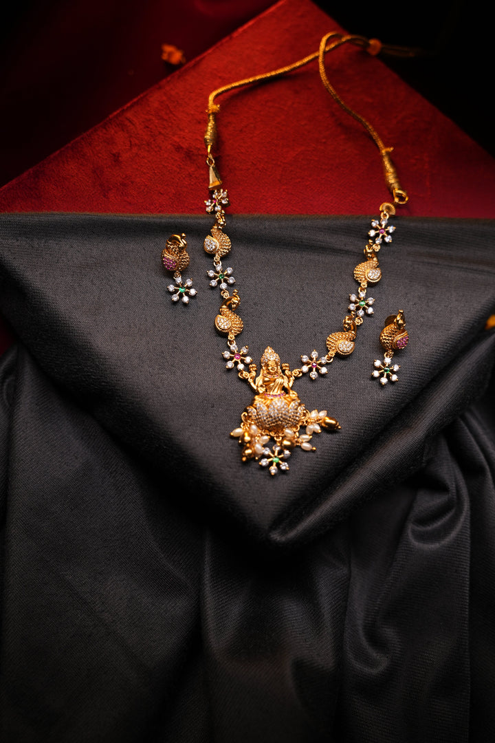 Divine Elegance , A traditional Necklace with a Mahalakshmi Pendant in red green and white stones with peacock detailing