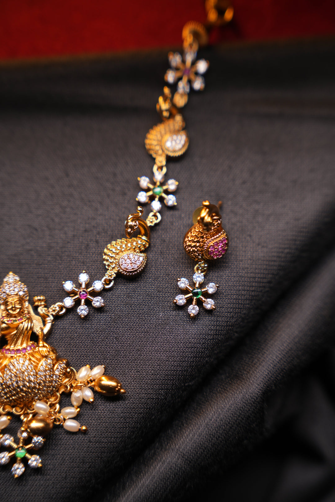 Divine Elegance , A traditional Necklace with a Mahalakshmi Pendant in red green and white stones with peacock detailing