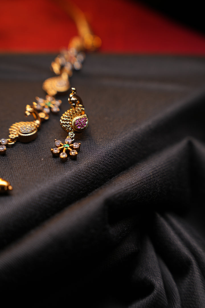 Divine Elegance , A traditional Necklace with a Mahalakshmi Pendant in red green and white stones with peacock detailing