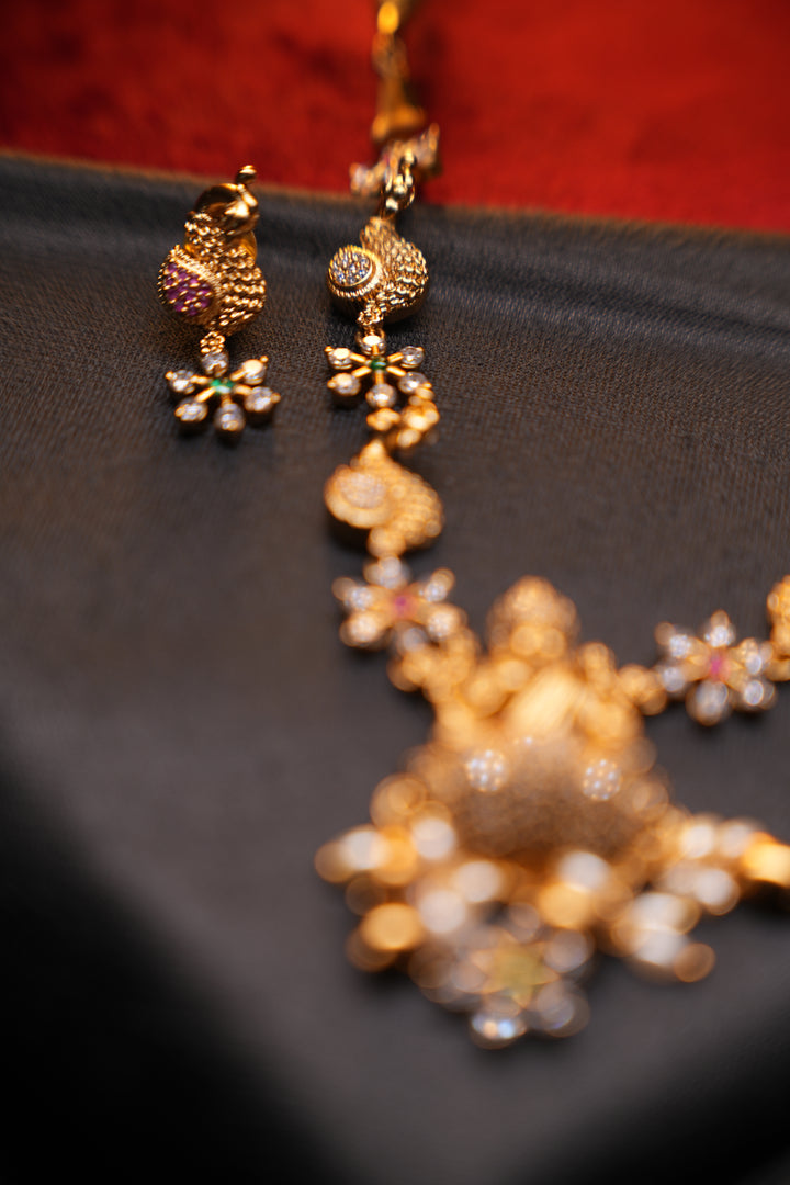Divine Elegance , A traditional Necklace with a Mahalakshmi Pendant in red green and white stones with peacock detailing