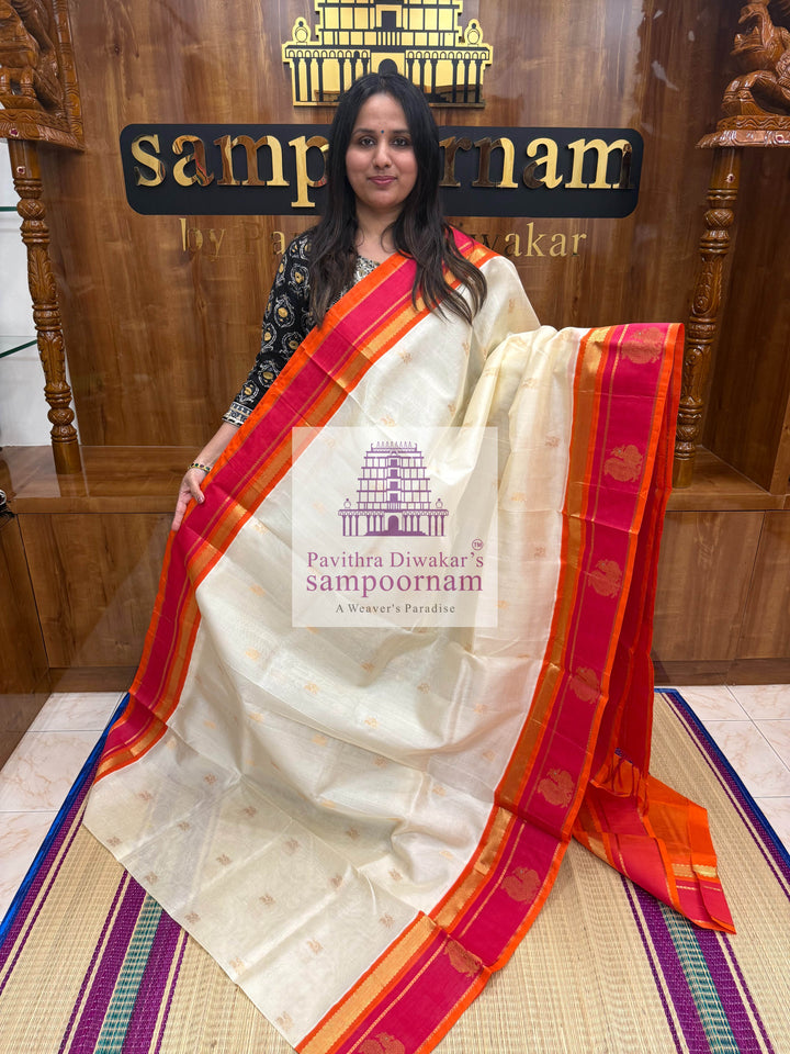 Offwhite with Orange, Rich Zari Butta in the Body, Traditional Borders with Peacock Motifs and Grand Pallu Korvai Silk Cotton Saree