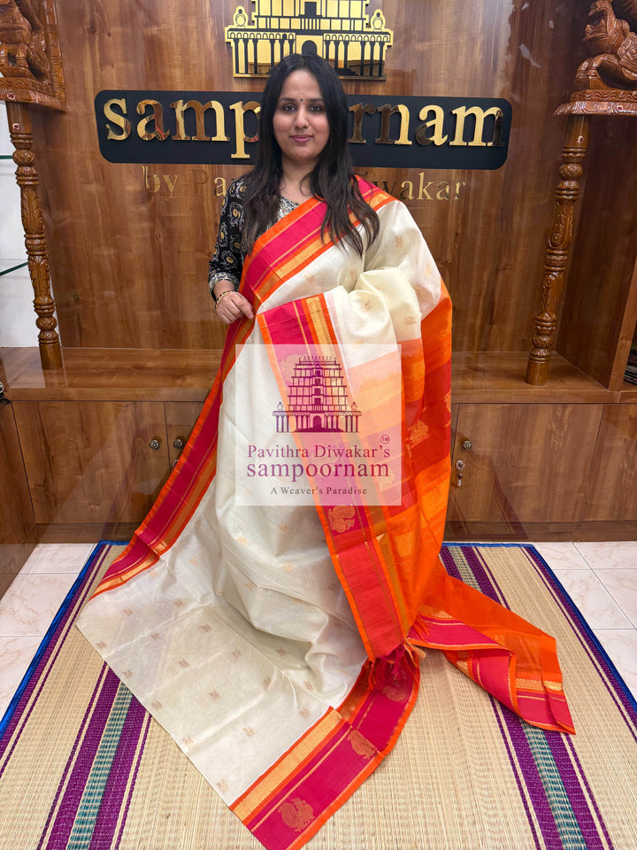 Offwhite with Orange, Rich Zari Butta in the Body, Traditional Borders with Peacock Motifs and Grand Pallu Korvai Silk Cotton Saree
