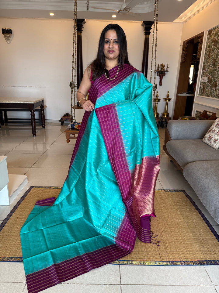 Rama Blue With Purple  colour , rich zari vertical line all over the body , traditional checks border and grand Pallu Pure Soft Silk Saree