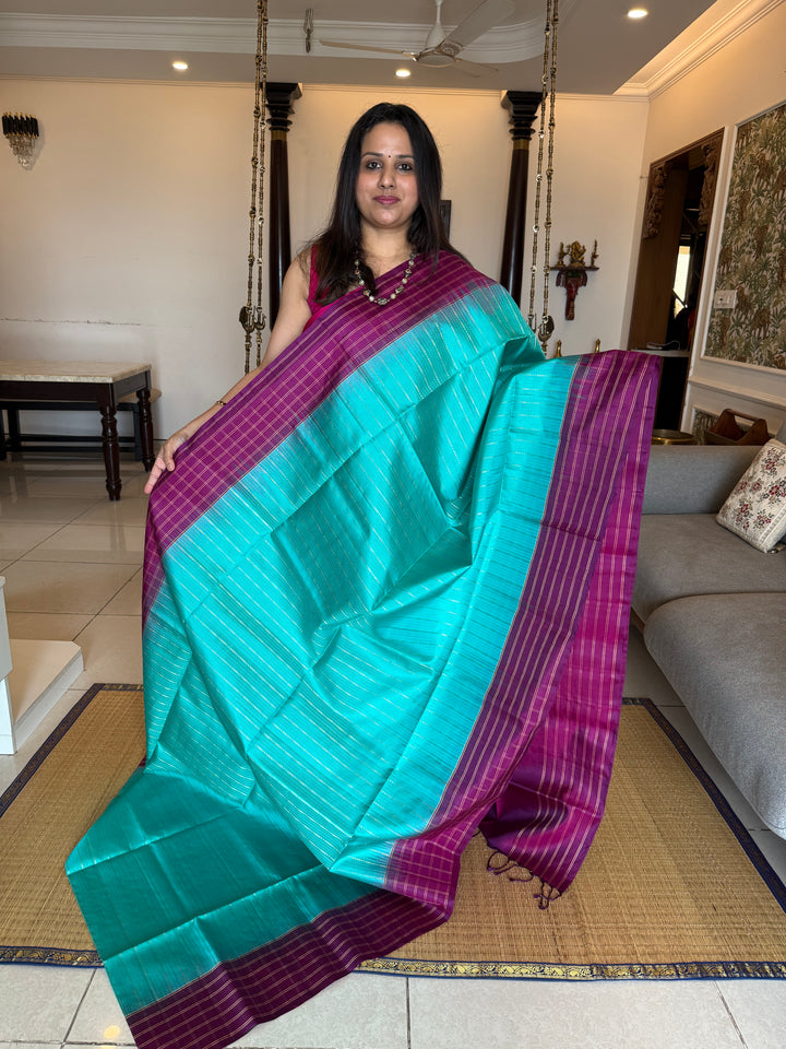 Rama Blue With Purple  colour , rich zari vertical line all over the body , traditional checks border and grand Pallu Pure Soft Silk Saree