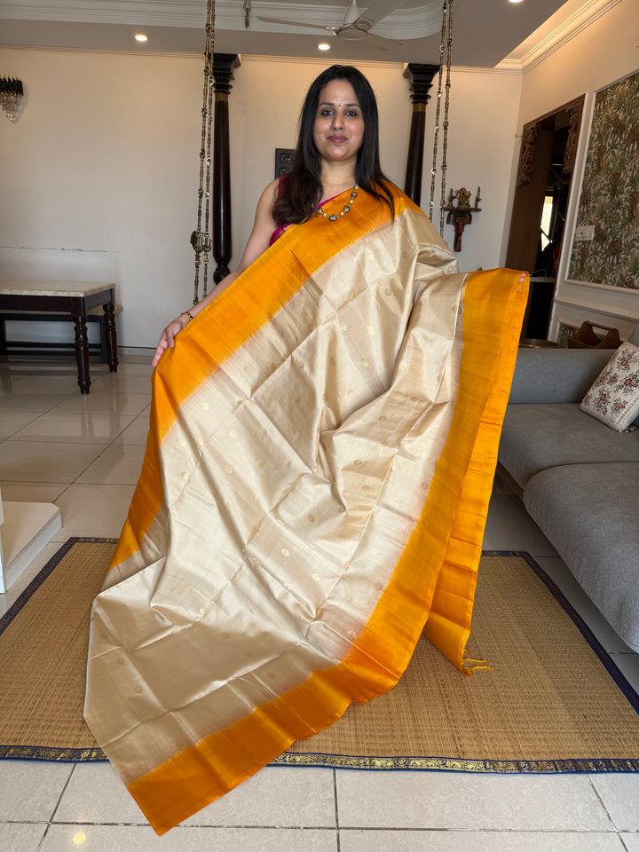 Offwhite with Mustard ,rich zari butta in the body and an elaborate rich Pallu Pure Soft Silk Saree