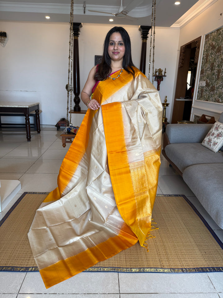 Offwhite with Mustard ,rich zari butta in the body and an elaborate rich Pallu Pure Soft Silk Saree