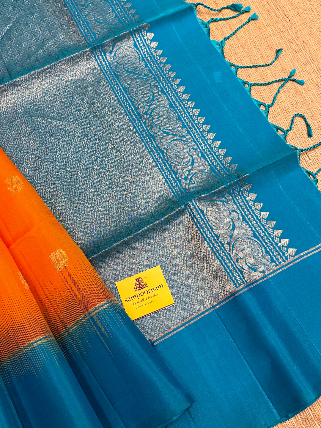 Fanta Orange with Turquoise Blue, rich zari butta in the body and an elaborate rich Pallu Pure Soft Silk Saree
