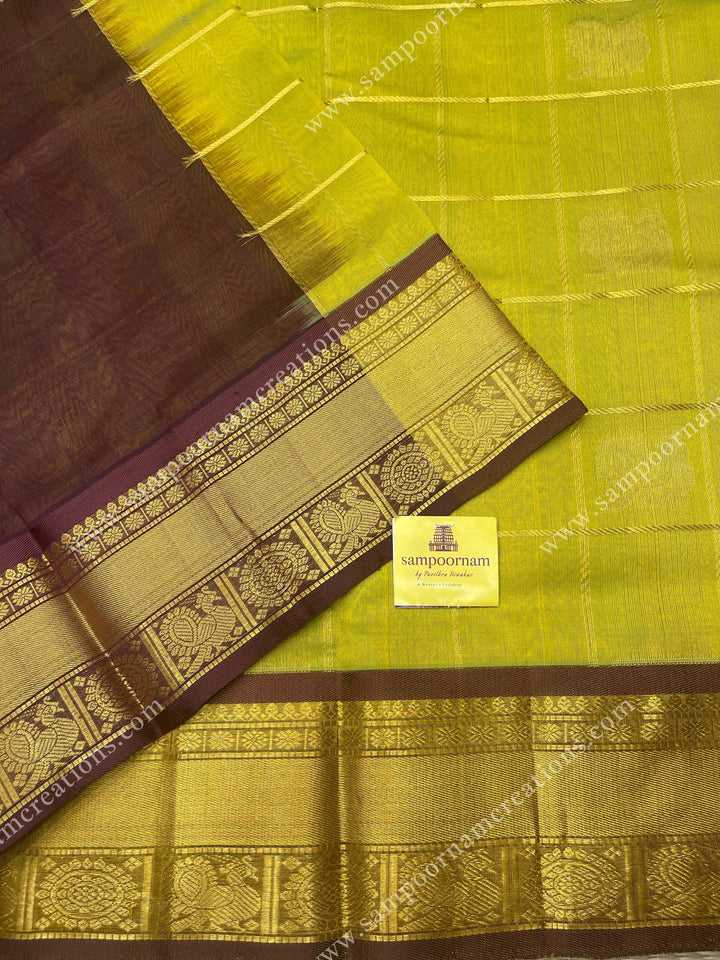 Lemon Green with Brown , rich Zari checks in the body , Mayil and Chakram rich butta in the body , traditional border and rich Pallu Silk Cotton Saree