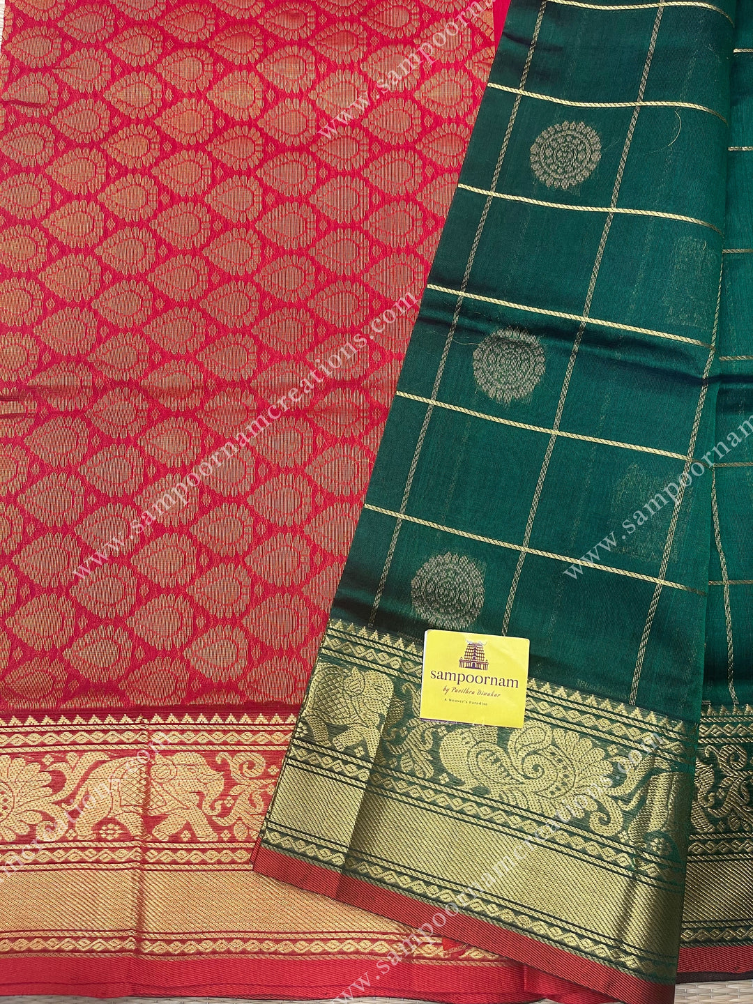 Green with Red , rich Zari checks in with Mayil and Chakram rich butta in the body , one side long traditional border and rich Pallu Silk Cotton Saree