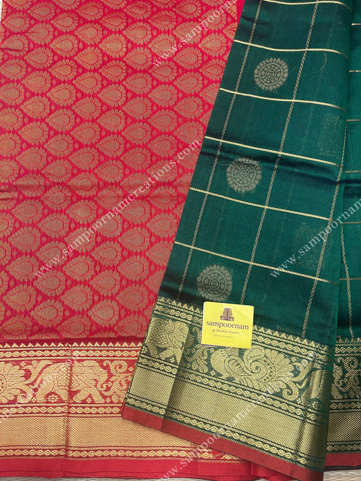 Green with Red , rich Zari checks in with Mayil and Chakram rich butta in the body , one side long traditional border and rich Pallu Silk Cotton Saree