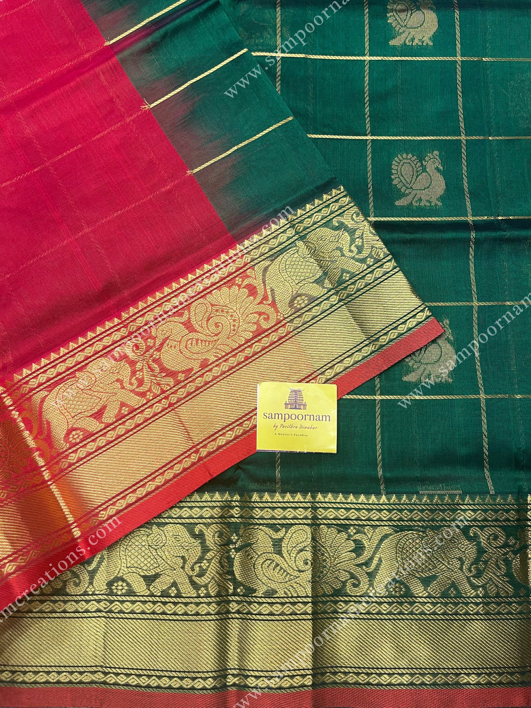 Green with Red , rich Zari checks in with Mayil and Chakram rich butta in the body , one side long traditional border and rich Pallu Silk Cotton Saree