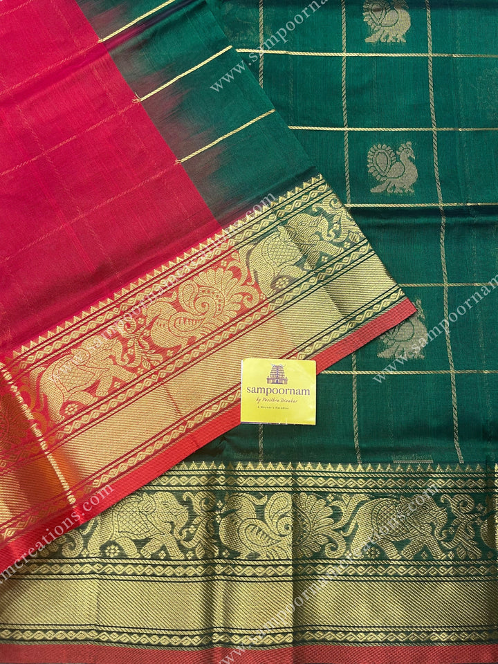 Green with Red , rich Zari checks in with Mayil and Chakram rich butta in the body , one side long traditional border and rich Pallu Silk Cotton Saree