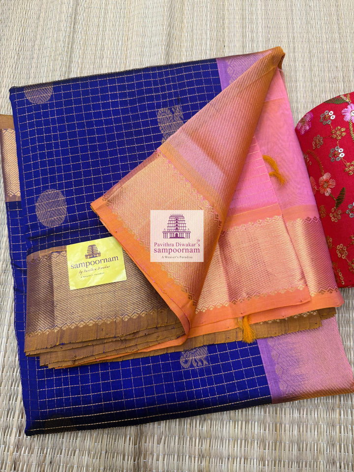 Blue with Baby Pink rich Zari checks in the body ,Mayil and Chakram rich butta in the body, traditional borders and rich Pallu Silk Cotton Saree