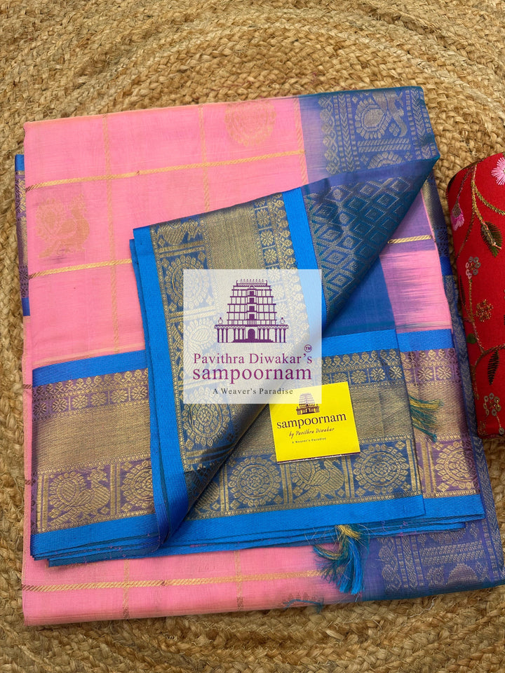 Baby Pink with Blue  , rich Zari checks in the body , Mayil and Chakram rich butta in the body , traditional borders and rich Pallu Silk Cotton Saree
