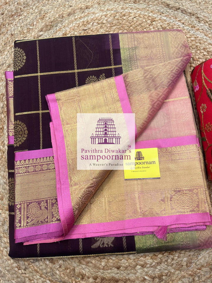 Brown with Peachish Pink, Baby Pink Selvedge , rich Zari checks in the body , Mayil and Chakram rich butta in the body , traditional borders and rich Pallu Silk Cotton Saree