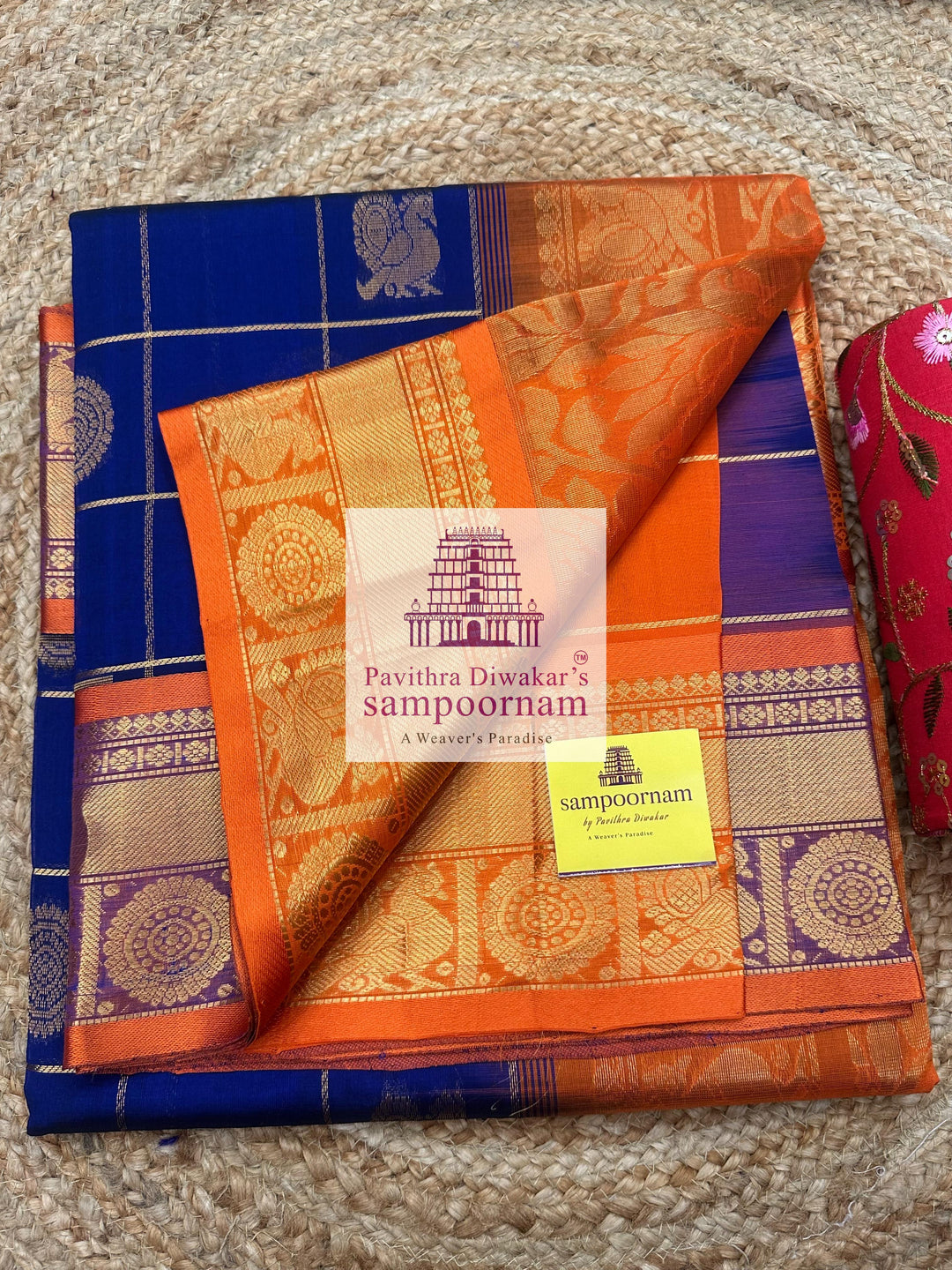 Blue with Orange  , rich Zari checks in the body , Mayil and Chakram rich butta in the body , traditional borders and rich Pallu Silk Cotton Saree