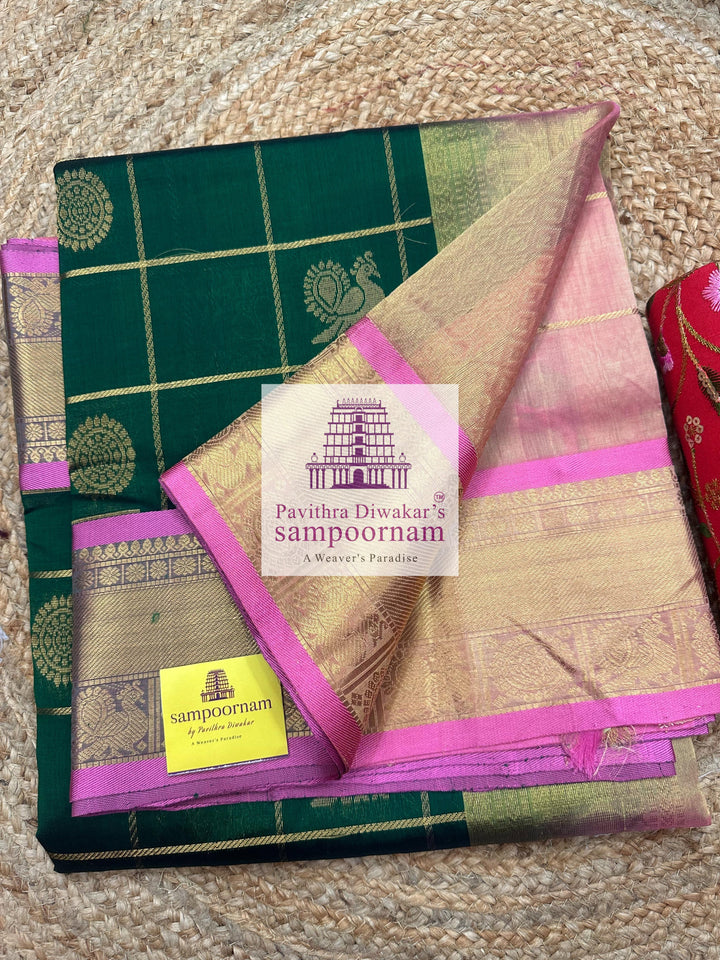 Bottle Green with Peachish Pink , Baby Pink Selvedge  , rich Zari checks in the body , Mayil and Chakram rich butta in the body , traditional borders and rich Pallu Silk Cotton Saree