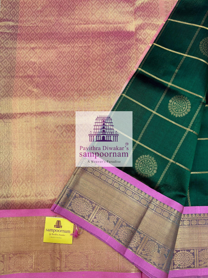 Bottle Green with Peachish Pink , Baby Pink Selvedge  , rich Zari checks in the body , Mayil and Chakram rich butta in the body , traditional borders and rich Pallu Silk Cotton Saree