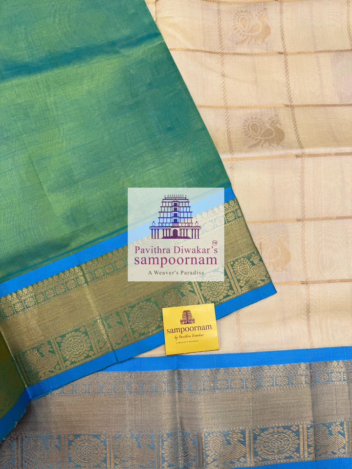 Offwhite  with Blue  , rich Zari checks in the body , Mayil and Chakram rich butta in the body , traditional borders and rich Pallu Silk Cotton Saree
