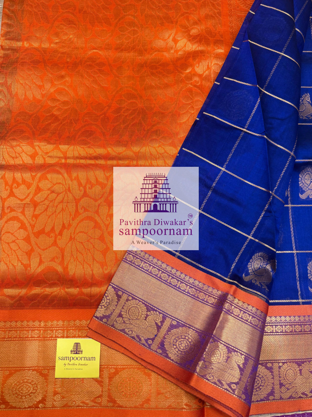 Blue with Orange  , rich Zari checks in the body , Mayil and Chakram rich butta in the body , traditional borders and rich Pallu Silk Cotton Saree