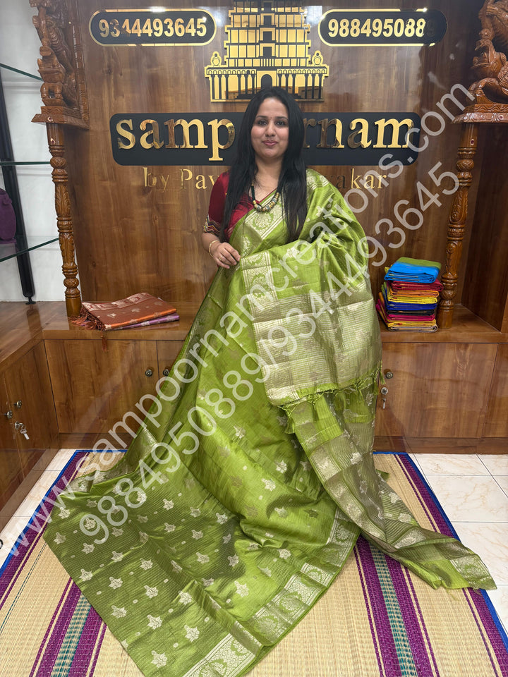 Leaf Green , Silver Floral buttas in the body with Silver Zari Border , Tissue Pallu and Tissue Blouse  , Semi Tussar Saree