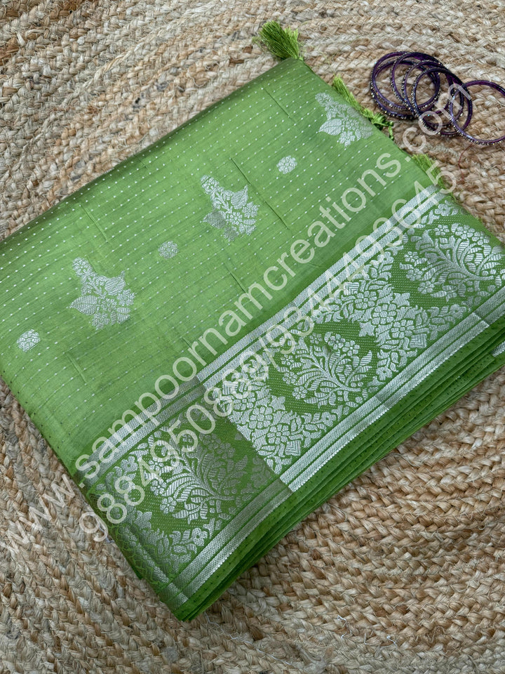 Leaf Green , Silver Floral buttas in the body with Silver Zari Border , Tissue Pallu and Tissue Blouse  , Semi Tussar Saree