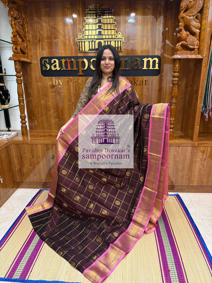 Brown with Peachish Pink, Baby Pink Selvedge , rich Zari checks in the body , Mayil and Chakram rich butta in the body , traditional borders and rich Pallu Silk Cotton Saree
