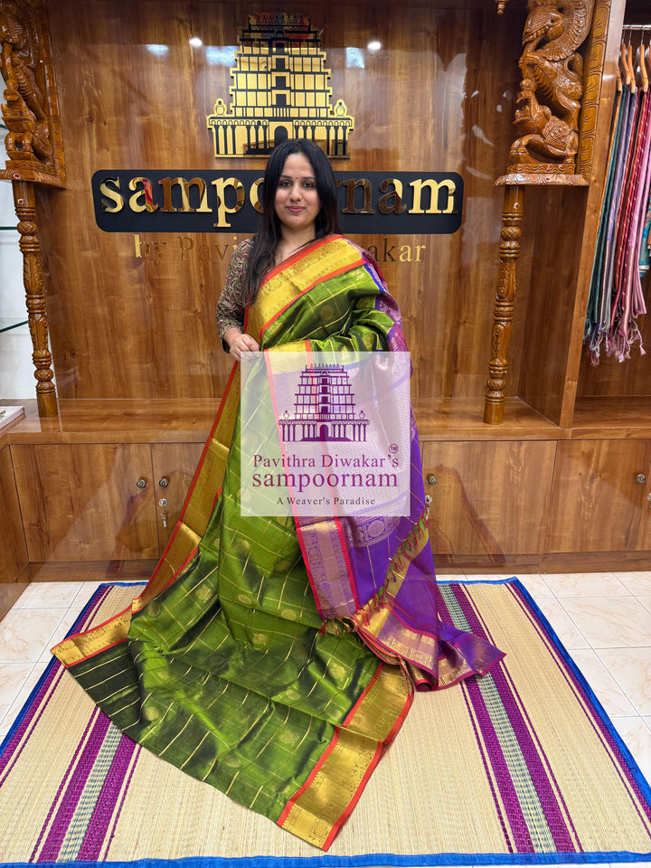 Green with Purple , Red Selvedge , rich Zari checks in the body , Mayil and Chakram rich butta in the body , traditional borders and rich Pallu Silk Cotton Saree