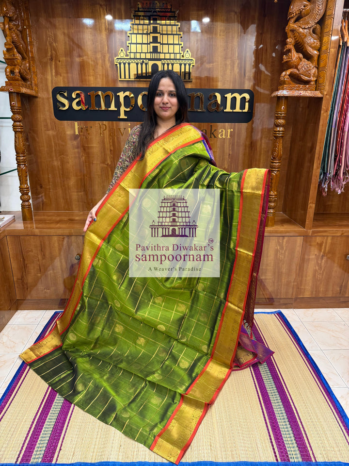 Green with Purple , Red Selvedge , rich Zari checks in the body , Mayil and Chakram rich butta in the body , traditional borders and rich Pallu Silk Cotton Saree