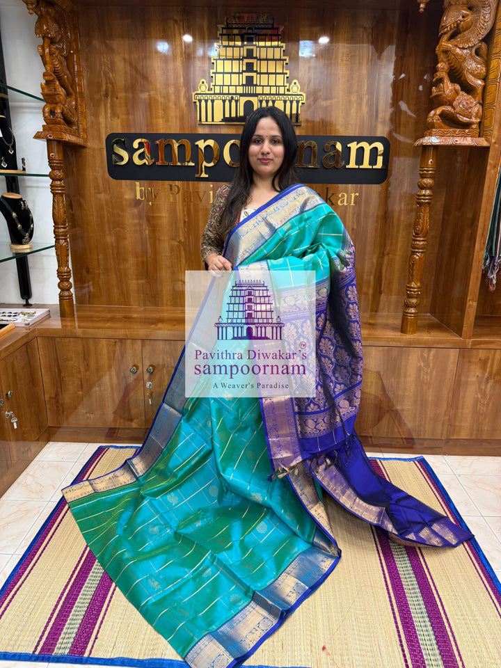 Ramar Green with Blue  , rich Zari checks in the body , Mayil and Chakram rich butta in the body , traditional borders and rich Pallu Silk Cotton Saree
