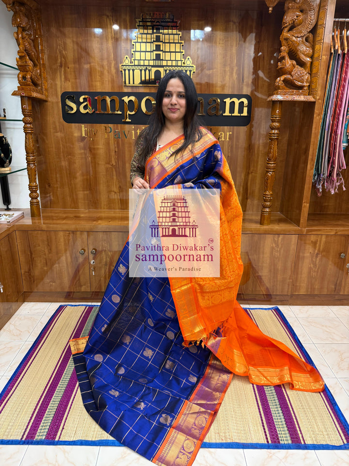 Blue with Orange  , rich Zari checks in the body , Mayil and Chakram rich butta in the body , traditional borders and rich Pallu Silk Cotton Saree