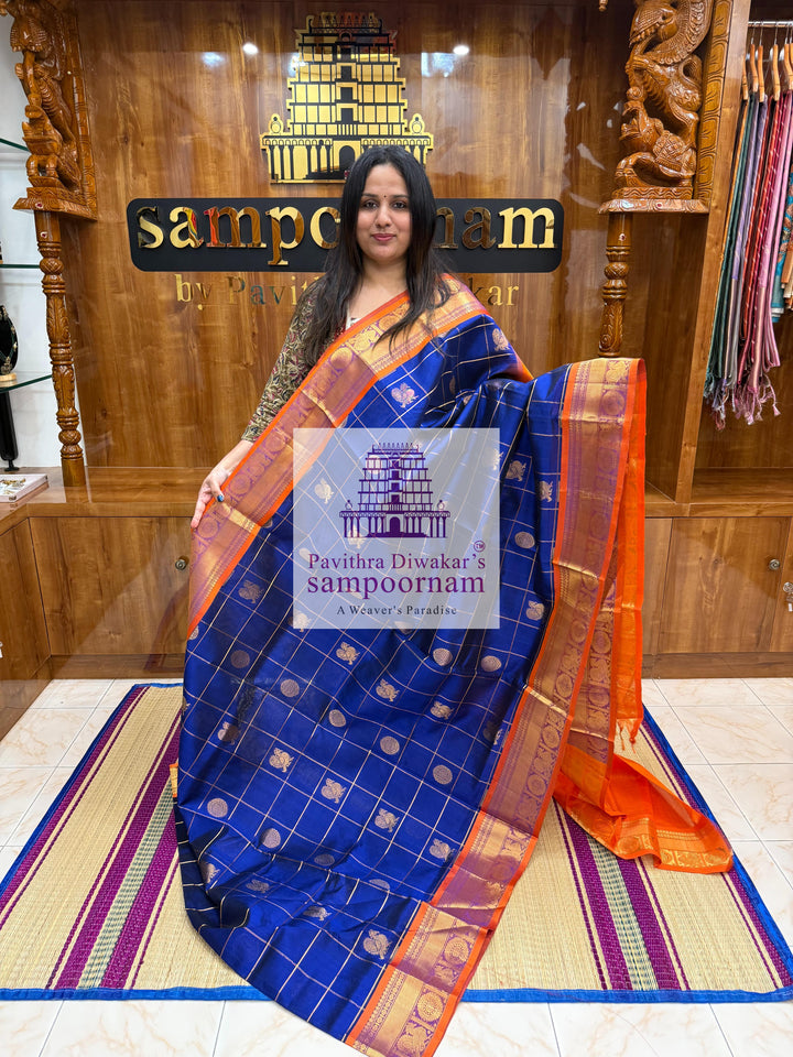 Blue with Orange  , rich Zari checks in the body , Mayil and Chakram rich butta in the body , traditional borders and rich Pallu Silk Cotton Saree