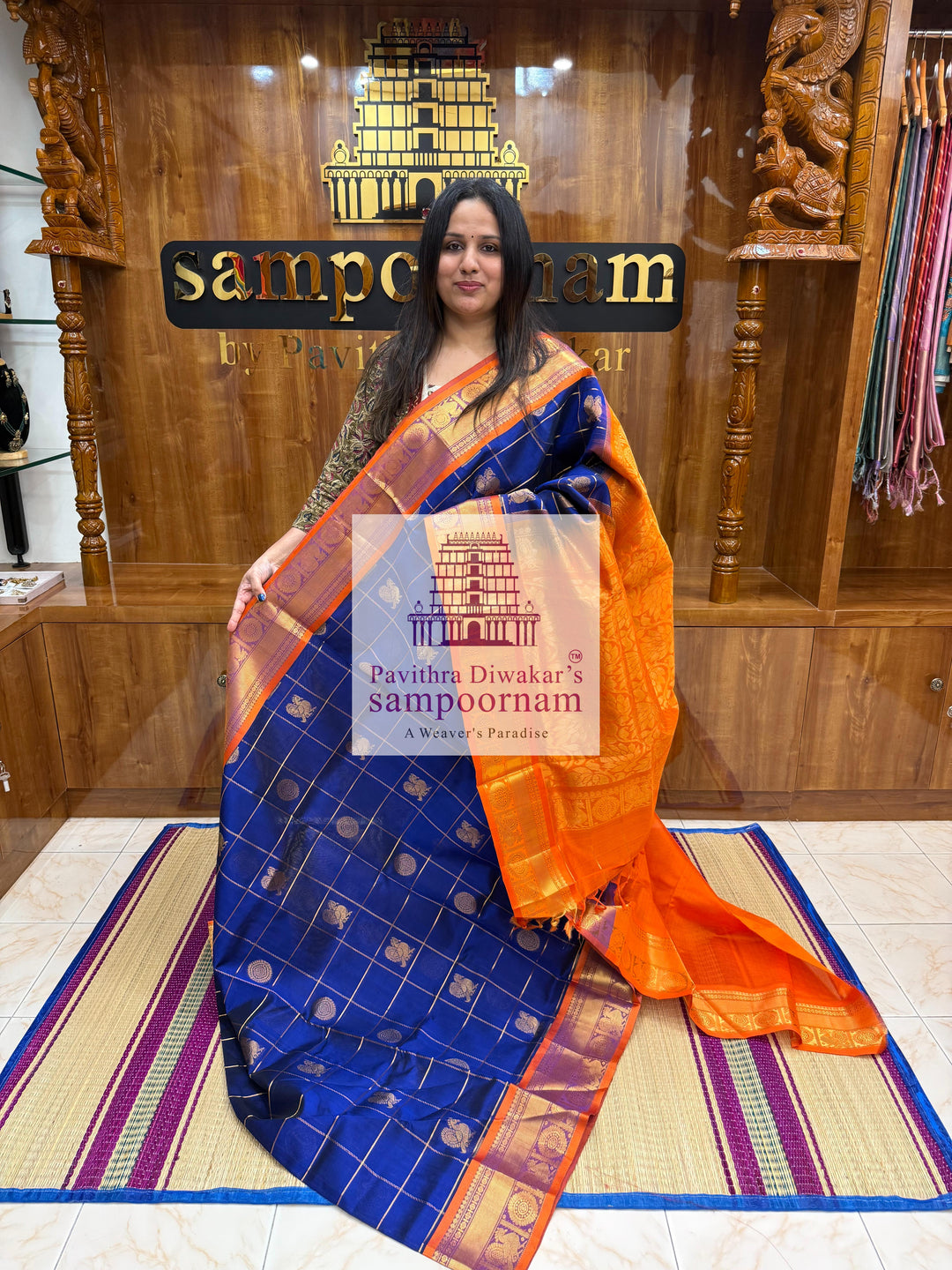 Blue with Orange  , rich Zari checks in the body , Mayil and Chakram rich butta in the body , traditional borders and rich Pallu Silk Cotton Saree