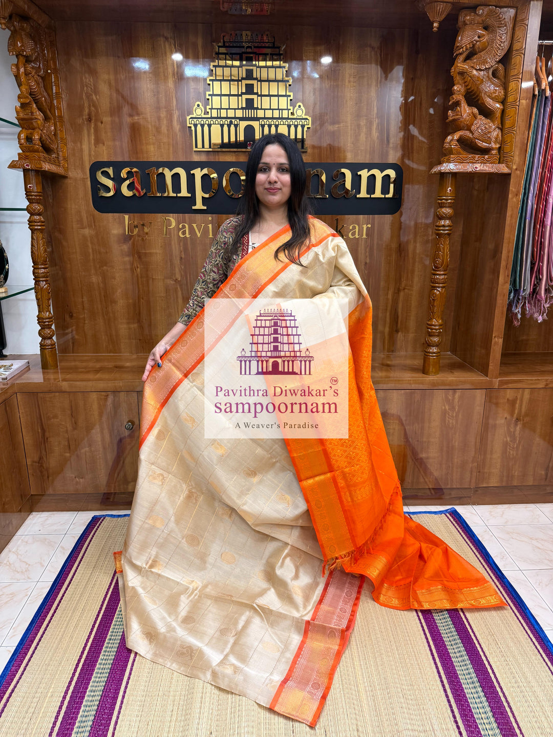 Offwhite with Orange , rich Zari checks in the body , Mayil and Chakram rich butta in the body , traditional borders and rich Pallu Silk Cotton Saree