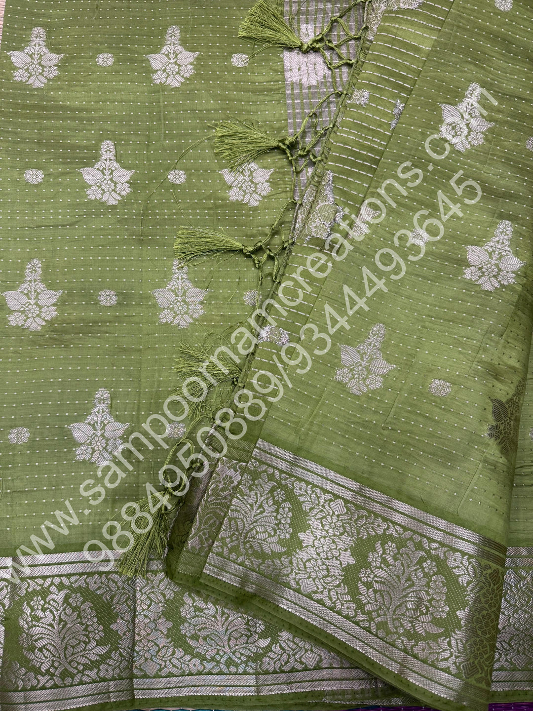 Leaf Green , Silver Floral buttas in the body with Silver Zari Border , Tissue Pallu and Tissue Blouse  , Semi Tussar Saree