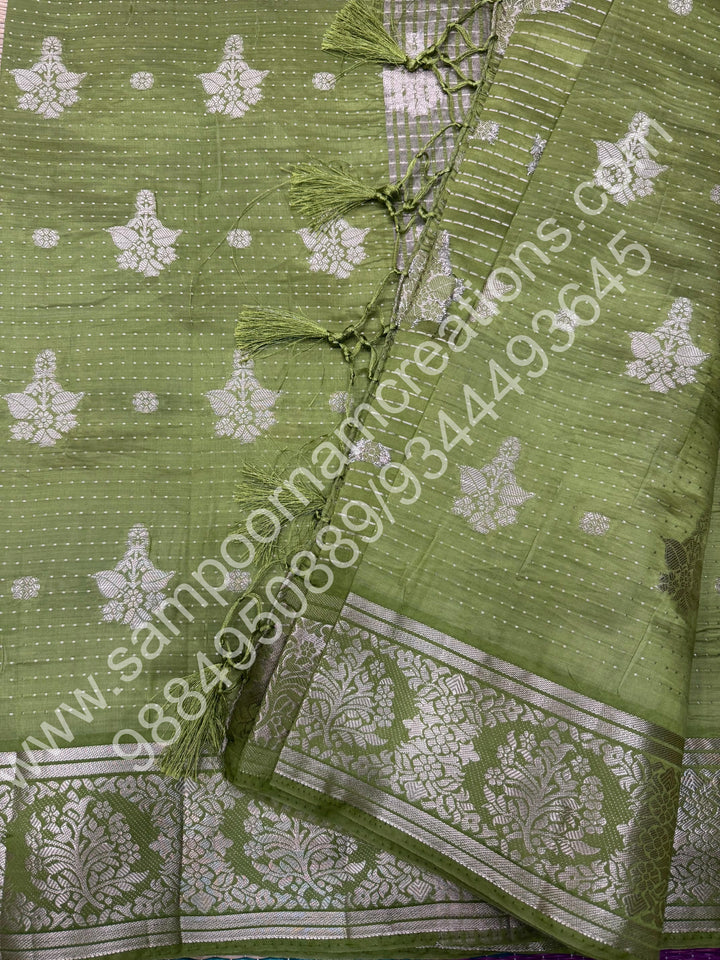 Leaf Green , Silver Floral buttas in the body with Silver Zari Border , Tissue Pallu and Tissue Blouse  , Semi Tussar Saree