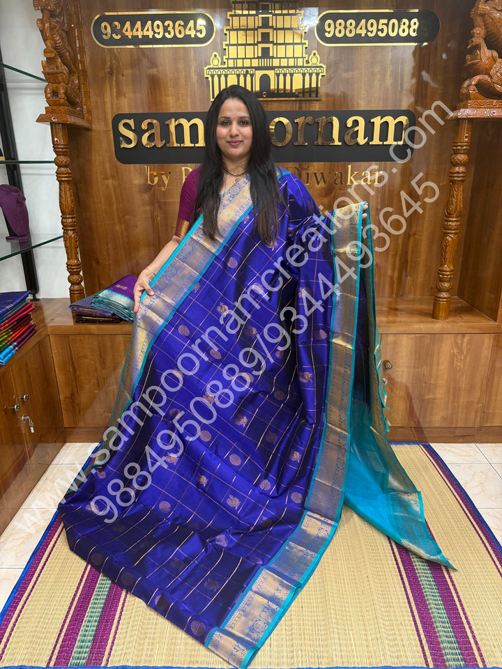Indigo Blue with Turquoise Blue , Rich Mayil and Chakram butta in the body with Zari Checks , Traditional borders and Rich Pallu Pure Silk Cotton Saree