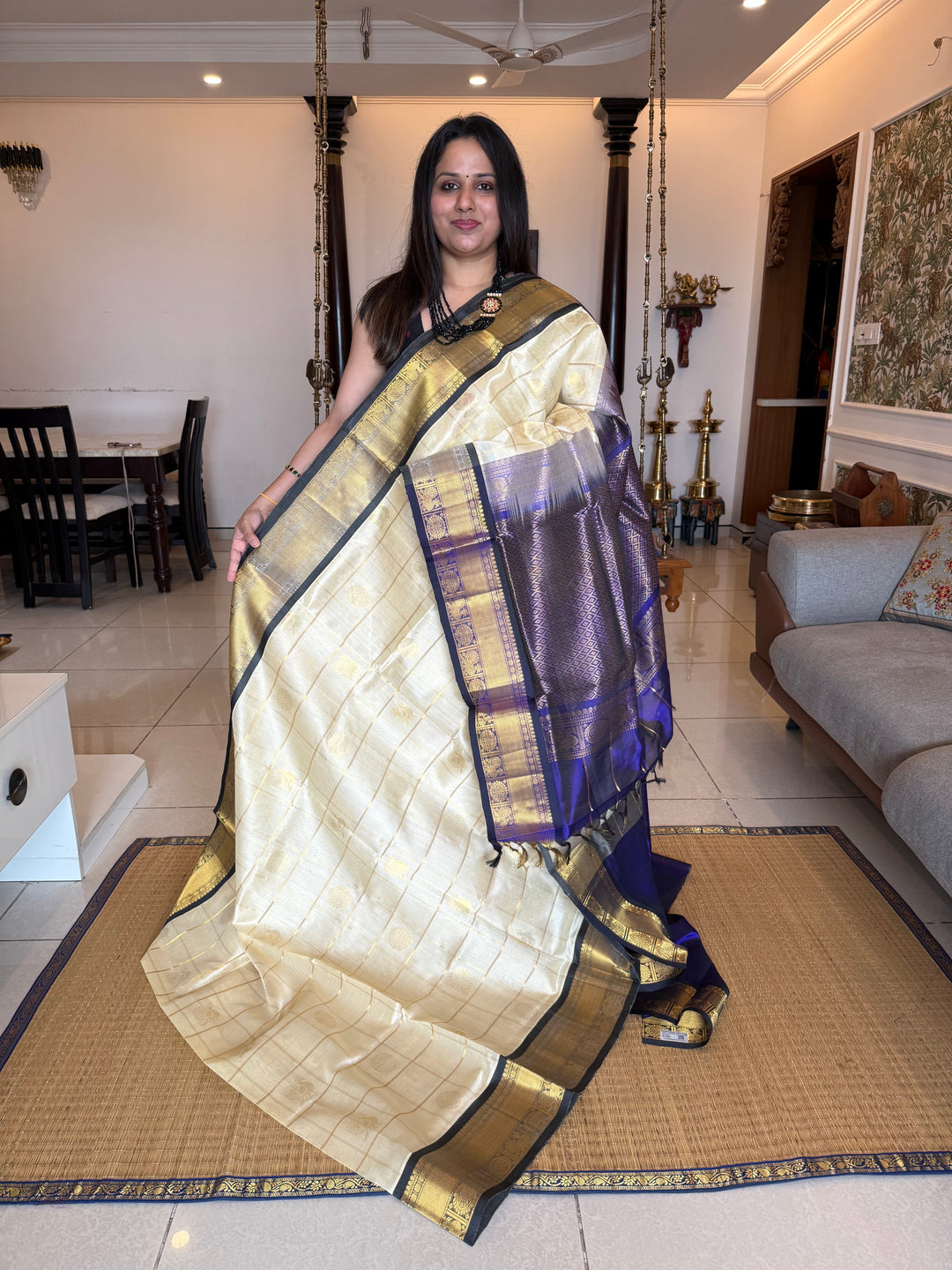 Offwhite with Dark Blue colour ,checks in the body with Mayil Chakram butta , traditional border and rich Pallu Silk Cotton Saree